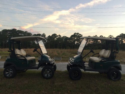 Two complete two-seater turnkey golf carts facing each other at sunset